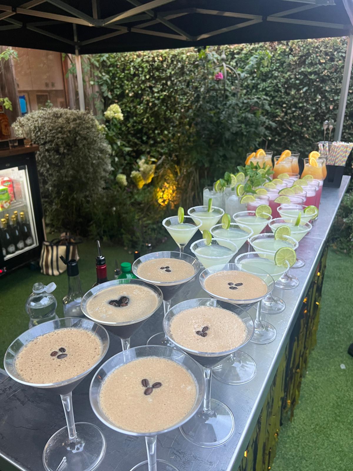 Full cocktail spread at a garden event — espresso martinis, margaritas, and more
