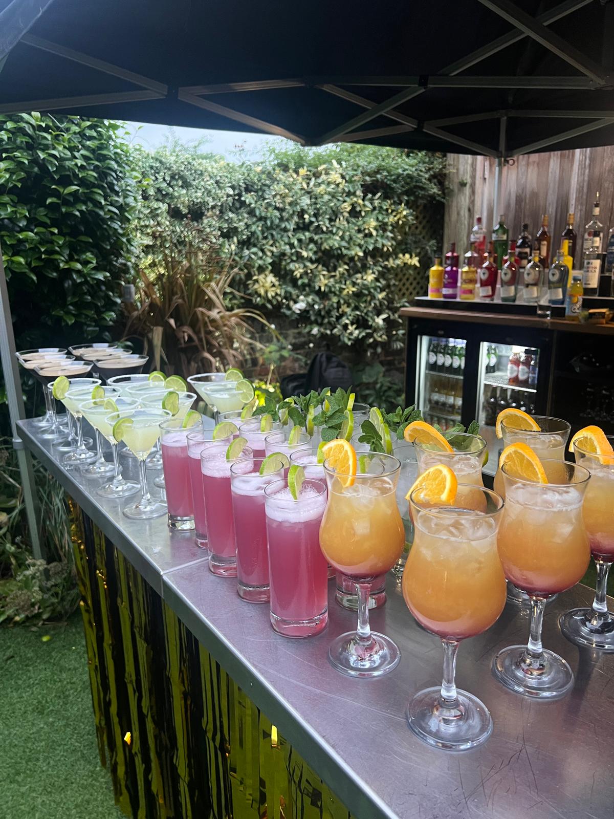Espresso martinis with coffee beans alongside a full cocktail spread at a garden party