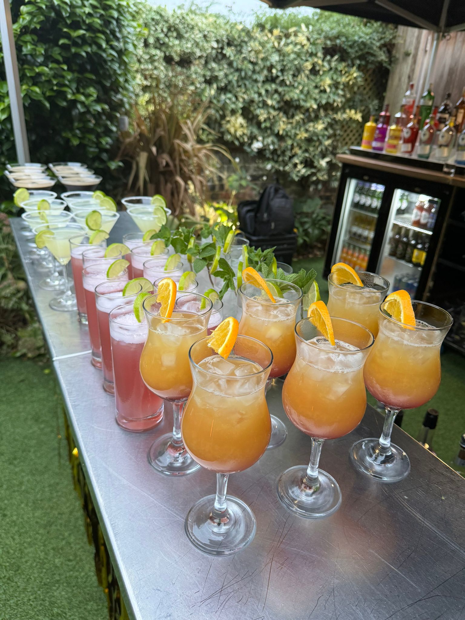 Colourful cocktails including tequila sunrise and pink lemonade on a mobile bar