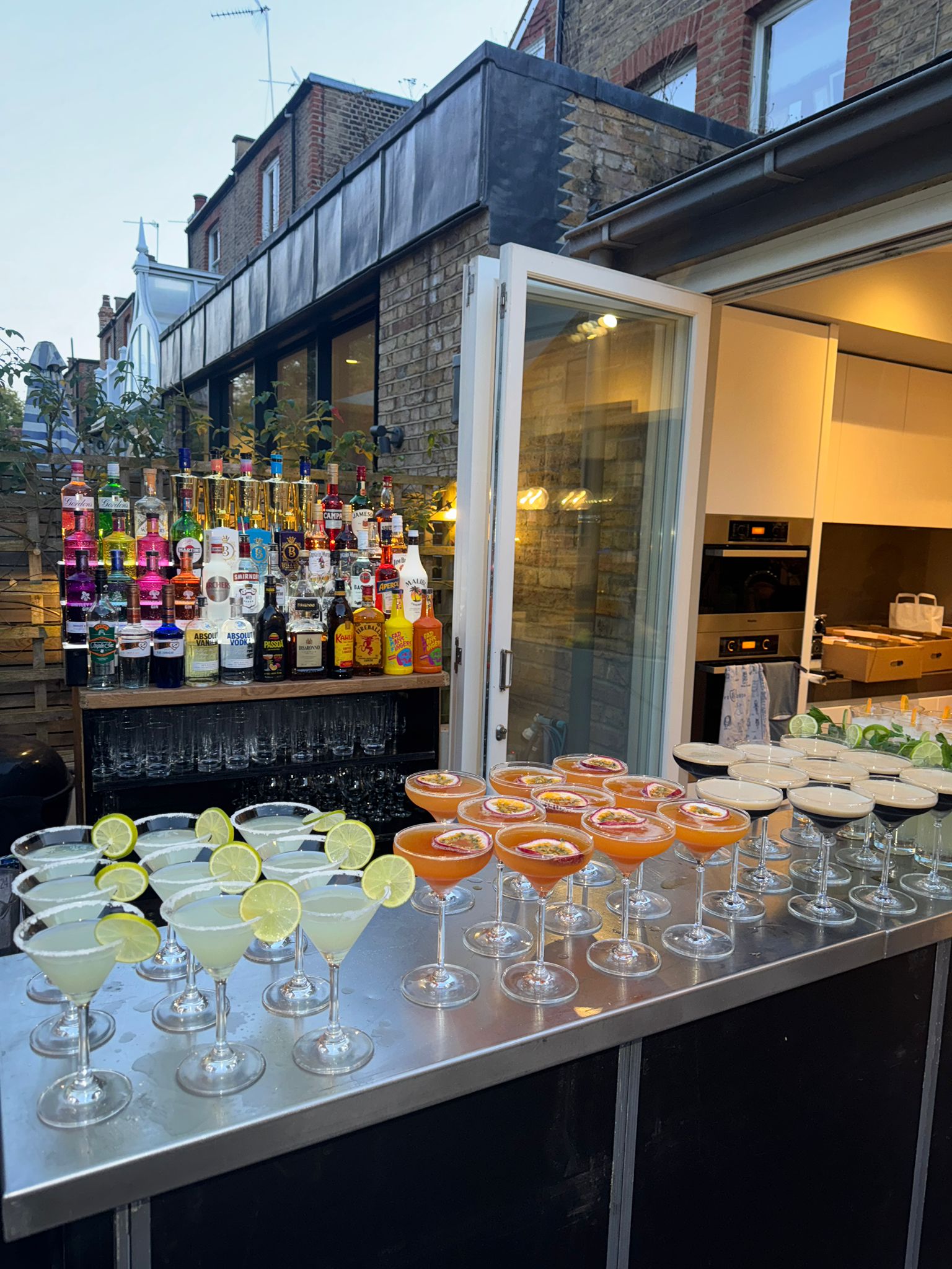 Mobile bar setup in an urban garden with margaritas and pornstar martinis ready to serve