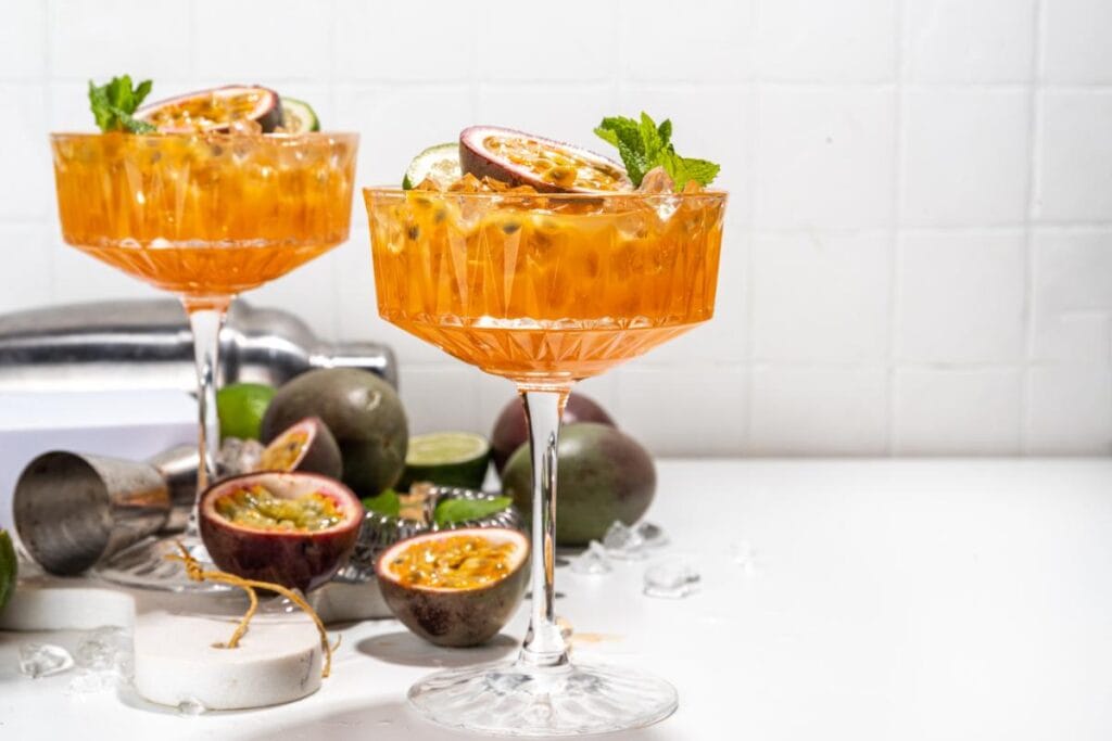2 glasses of Chinola mojito with sliced passion fruits on the side.