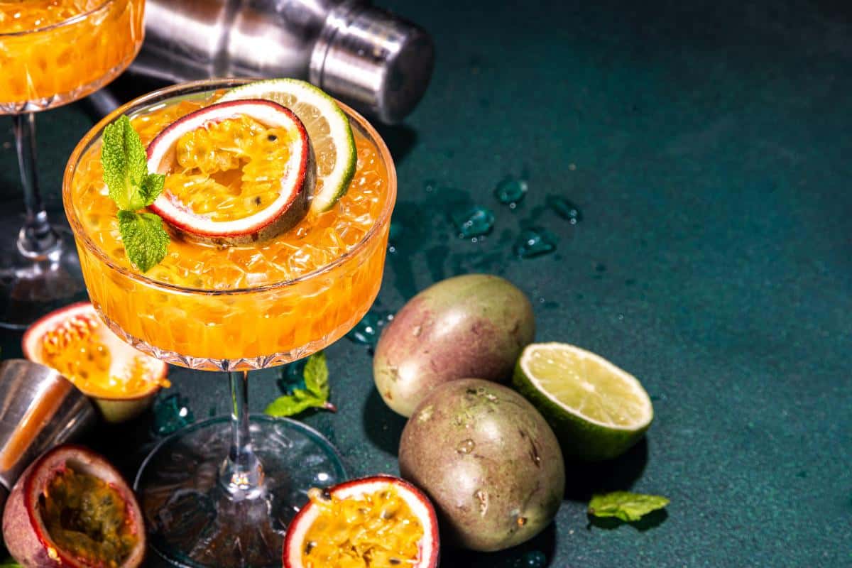 Refreshing passion fruit cocktail garnished with citrus slices and mint, served in an elegant coupe glass at The Sesh Bars mobile bar hire London & Berkshire cocktail event.