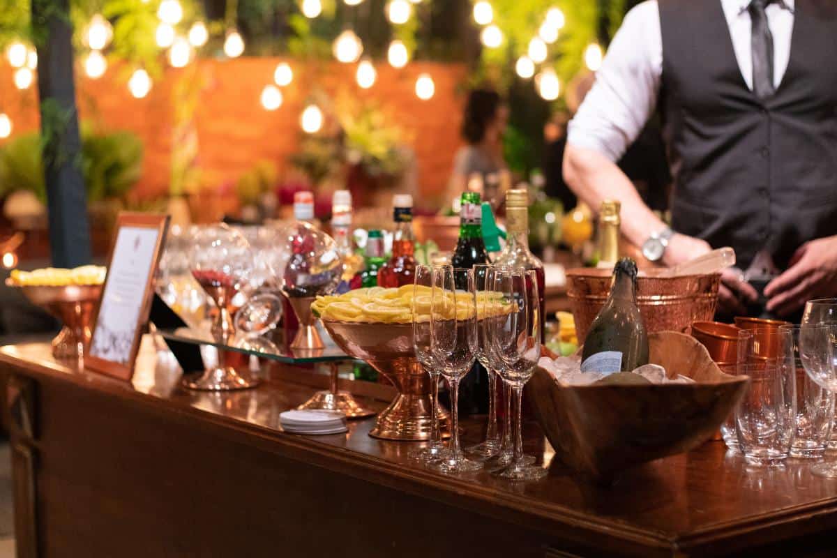 Elegant mobile bar setup with a variety of spirits, glasses, and garnishes at an outdoor event in London and Berkshire.