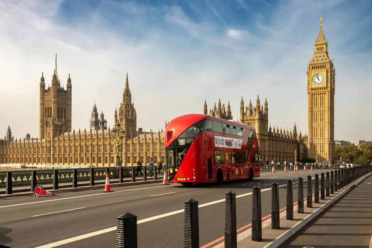 London double-decker bus passing iconic Big Ben and Houses of Parliament in central London, ready for a fun city tour or event.