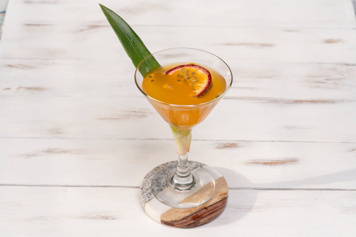 Pornstar martini mocktail in a martini glass garnished with passion fruit